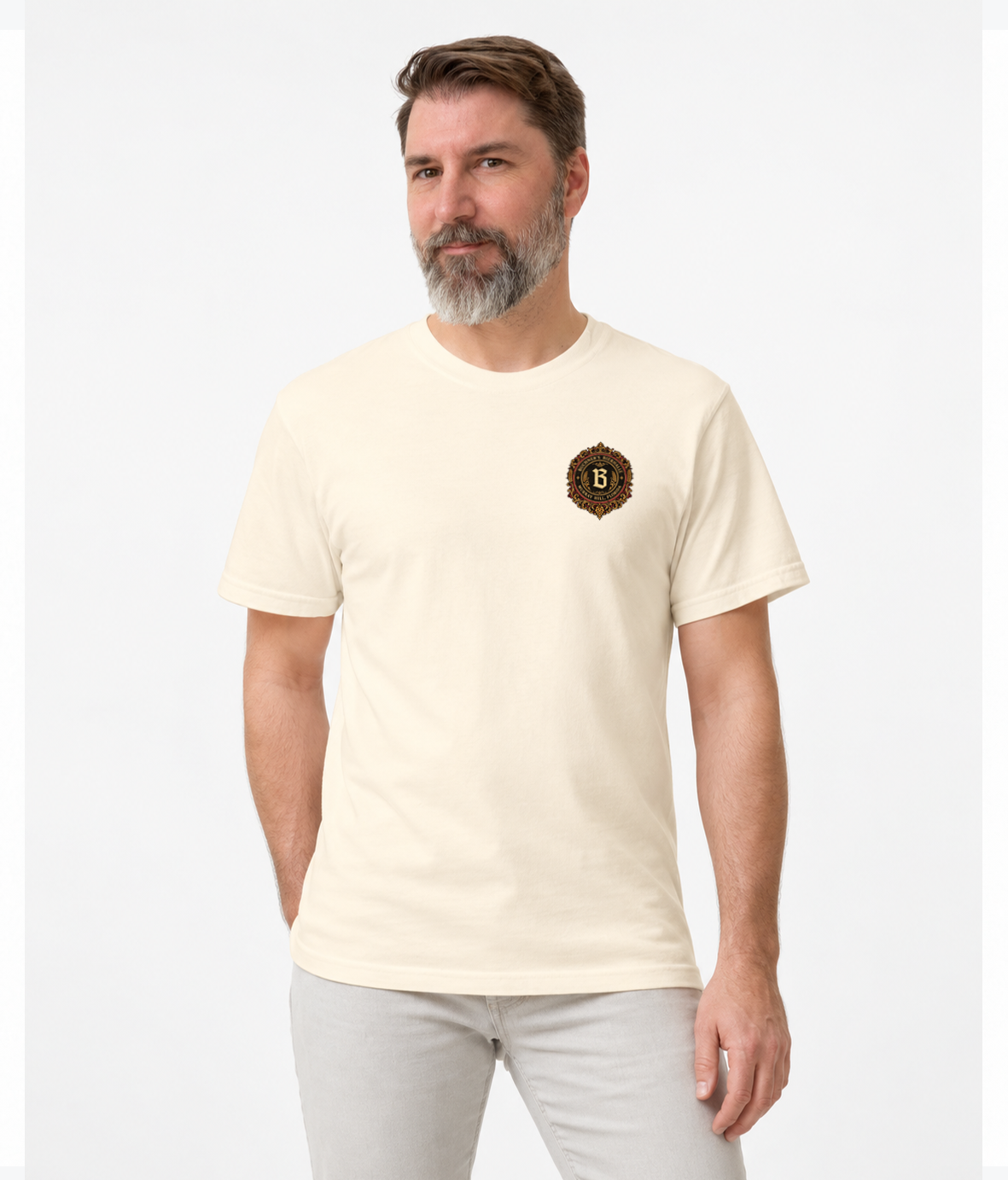 Front view of a model wearing the ivory Buchner's Bierhalle Oktoberfest 2026 commemorative T-shirt with a small stylized Buchner's crest on the left chest.